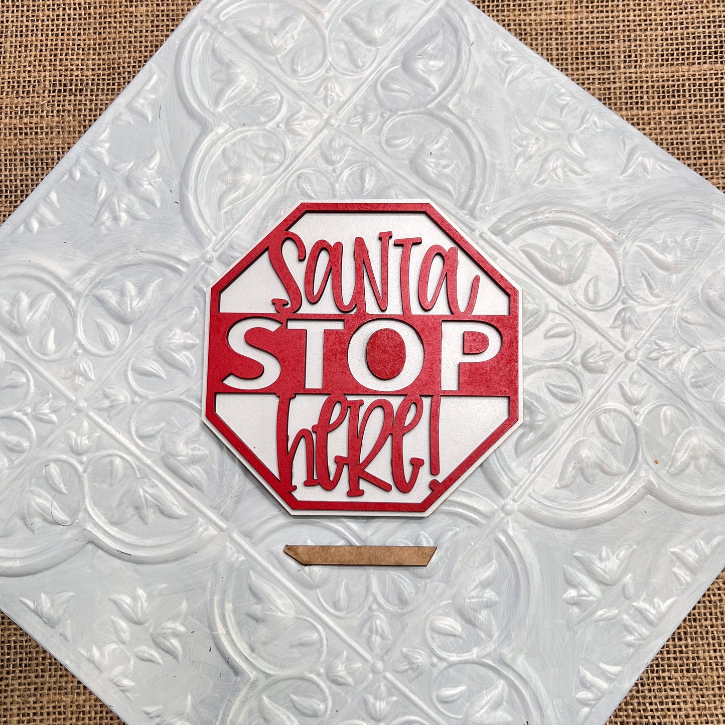 Janet's Craft Corner Christmas Mini Shelf Sitters feature a red and white octagonal sign reading "Santa STOP here!" in playful letters, displayed on a textured silver and white background with burlap accents.