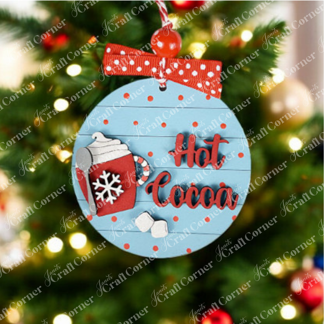 Decorate your home with Janet's Craft Corner Hot Cocoa Mini Shelf Sitters, a DIY seasonal home decor kit. This set features a round blue ornament with red polka dots, a red mug with whipped cream, and festive accents—perfect holiday charm!.