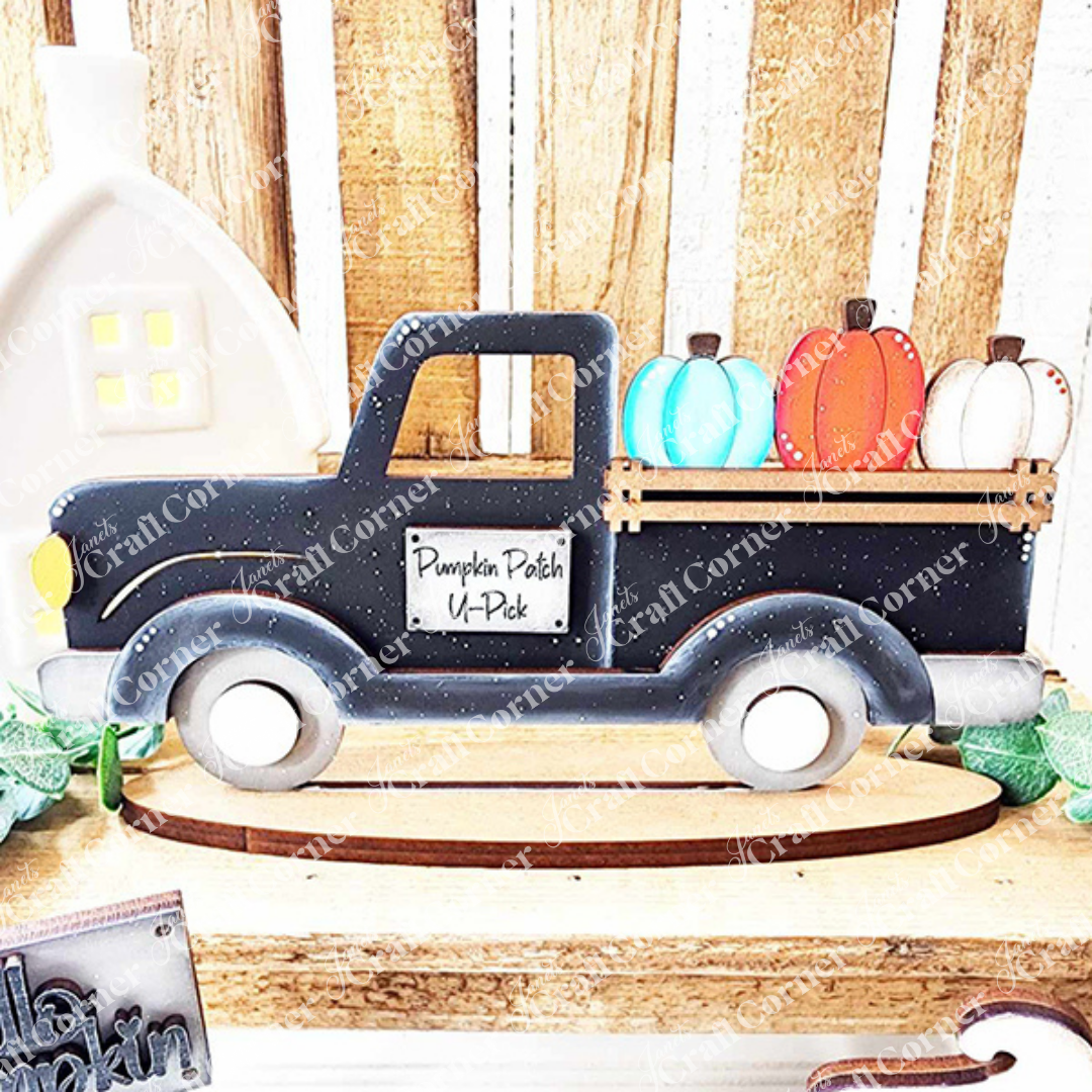 The Janet's Craft Corner Fall Harvest Mini Shelf Sitters DIY kit features a dark blue vintage truck with a "Pumpkin Patch U-Pick" sign and colorful pumpkins—perfect autumn decor displayed against a rustic wooden backdrop. Set of 1; choose from 9 styles.