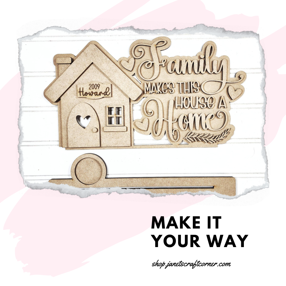 The Family Home Word Art Votive Holder Shelf Sitter from Janet's Craft Corner is a charming DIY kit featuring a wooden cutout of a house with "Family makes this house a home." It offers personalization options like "2009" and "Howard" and includes a practical key holder on a white background with pink brushstrokes. MAKE IT YOUR WAY.