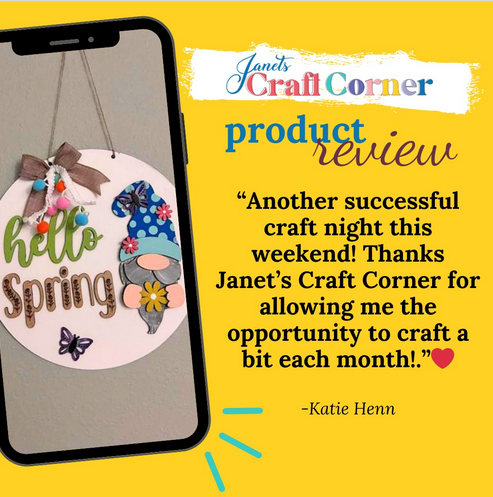 An iPhone displays the "Hello Spring Gnome Door Hanger" DIY kit. Text reads: "Another successful craft night this weekend! Thanks to Janet's Craft Corner for monthly home décor projects!” -Katie Henn. Background is yellow and blue.