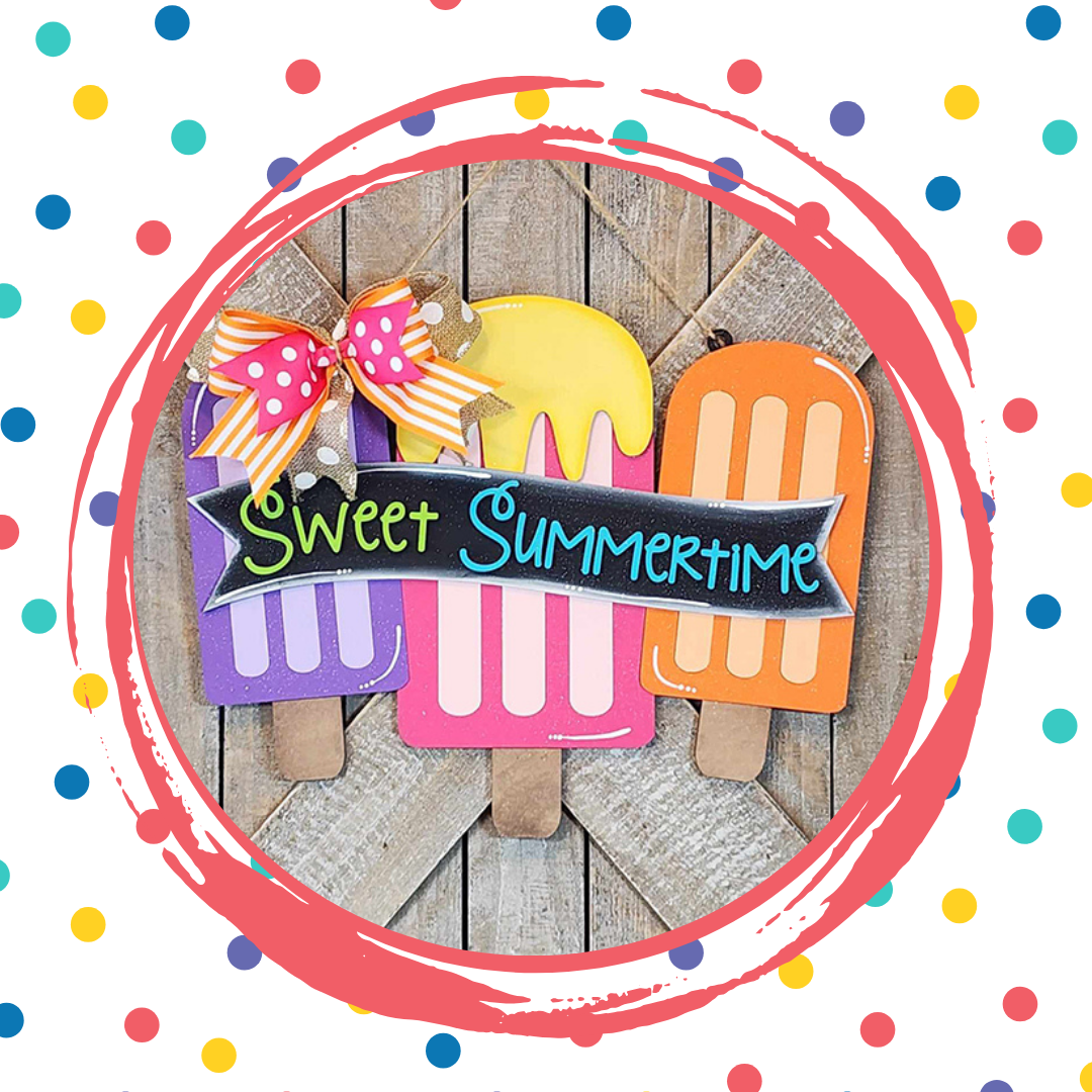 The Sweet Summertime Door Hanger from Janet's Craft Corner features colorful wooden popsicle cutouts with "Sweet Summertime" text and polka dot ribbon on a pink circle, creating charming home décor.