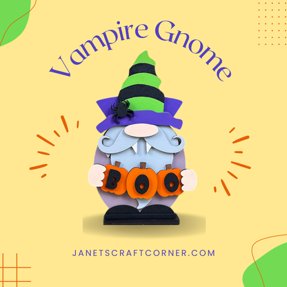 A Vampire Gnome sits with a green and black hat and purple cape, holding orange "BOO" letters. "Vampire Gnome" title above, with "janetscraftcorner.com" below on a light yellow background. Check out our Vampire Gnome Shelf Sitter DIY kit at Janet's Craft Corner for spooky decor!.