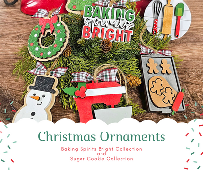 Festive Christmas ornaments from Janet's Craft Corner on a wooden background, featuring a wreath, baking utensils, a snowman, gingerbread cookies, and a red stocking. Text reads "Baking Spirits Bright Ornaments - Set of 4 - DIY craft kits." Ideal for personalized home décor or holiday charm.