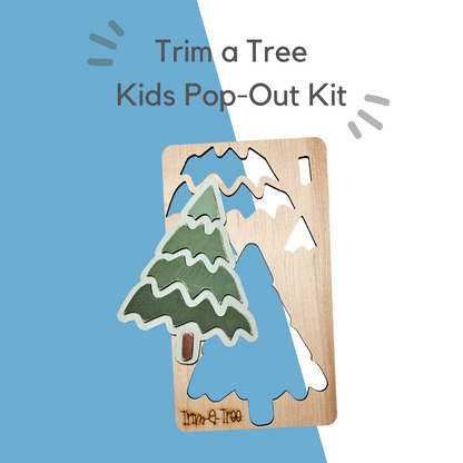 The "Trim a Tree Kids Pop-Out Kit" from Janet's Craft Corner features wooden cut-out panels with pop-out pieces that form an evergreen tree shape. The kit is ideal for festive holiday decorations against a blue and white backdrop.