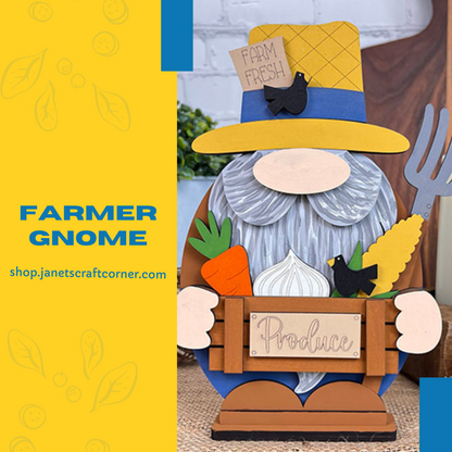 A whimsical farmer gnome from Janet's Craft Corner holds a "Produce" sign, with a yellow "Farm Fresh" hat and gray beard, adorned with carrot, corn, and bird accents. This charming farmhouse décor piece includes text: "Farmer Gnome," on a blue and yellow background. Product: Farmer Gnome Shelf Sitter Kit.