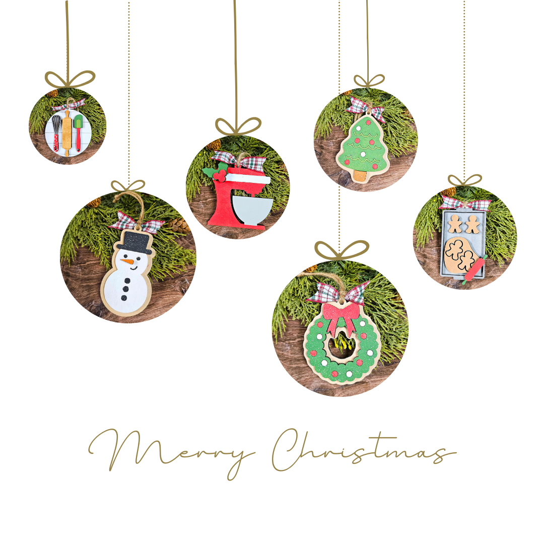 The Baking Spirits Bright Ornaments DIY Craft Kit by Janet's Craft Corner, featuring festive designs like a snowman, gingerbread man, stocking, and tree, hangs against a white backdrop with pine branch accents. Create personalized holiday décor with "Merry Christmas" text below.