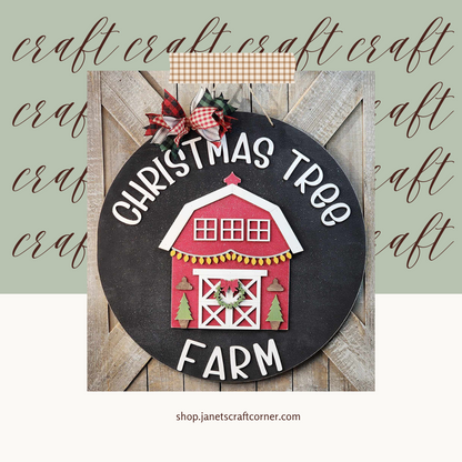 The festive "Christmas Tree Farm" door hanger from Janet's Craft Corner features a red barn and tree cutouts on wood panels with bows, enhanced by charming "craft" text. Get in the holiday spirit with this DIY kit at shop.janetscraftcorner.com.