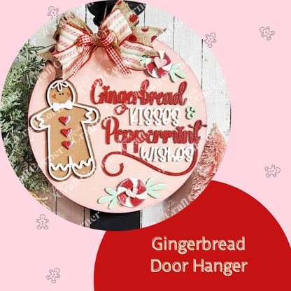 The Gingerbread Door Hanger from Janet's Craft Corner features a gingerbread figure, candy swirls, and "Gingerbread Kisses & Peppermint Wishes" text. This round pink piece is ideal for holiday decorating with a festive bow, charming elements, and hand-painted cheer—perfect DIY décor craft kit.