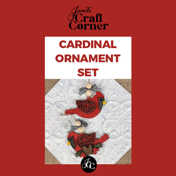 The image features two decorative Cardinal Ornaments with black and white bows for holiday décor on a textured white surface. The text "Janet's Craft Corner" and "Cardinal Ornament - DIY craft kit" is displayed on a vibrant red background.