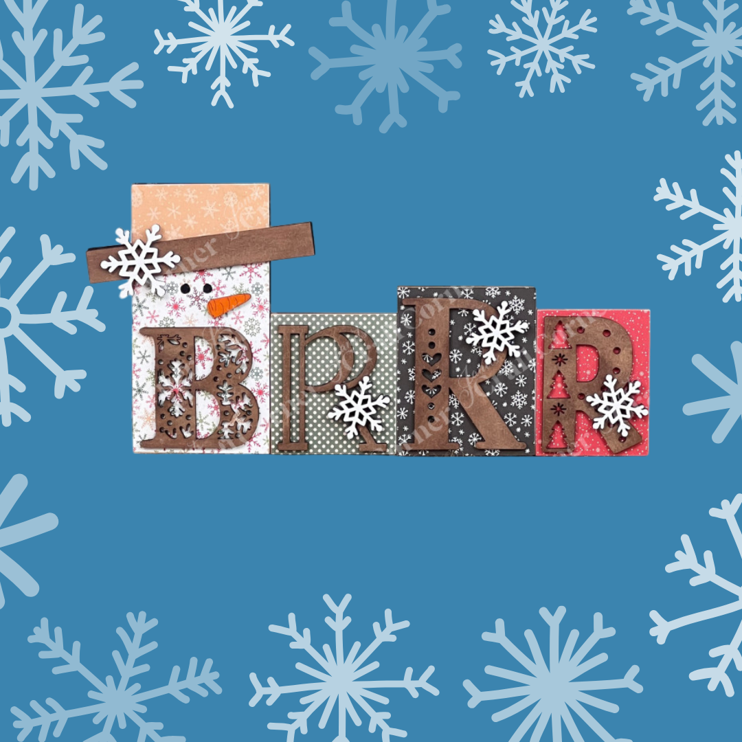 The Brrr Word Block Shelf Sitter by Janet's Craft Corner features "BRRR" with unique patterns in each letter, surrounded by white snowflakes on a blue background, perfect for personalizing your home decor.