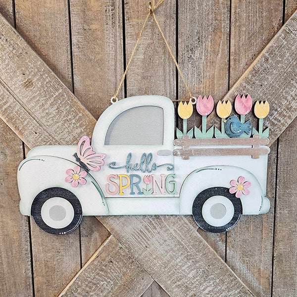 Immerse yourself in the spirit of spring with Janet's Craft Corner's charming "Hello Spring Truck Sign." This delightful wooden decoration showcases a vintage truck adorned with "Hello Spring," its bed overflowing with vibrant tulips and a butterfly, all against a lovely rustic wood backdrop.