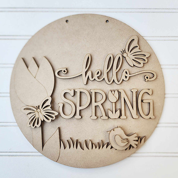 Create your own seasonal charm with Janet's Craft Corner's "Hello Spring Round Door Hanger" DIY kit, featuring decorative "hello spring" on white paneling and cut-out butterfly, flower, bird, and grass shapes—perfect for your spring decor.