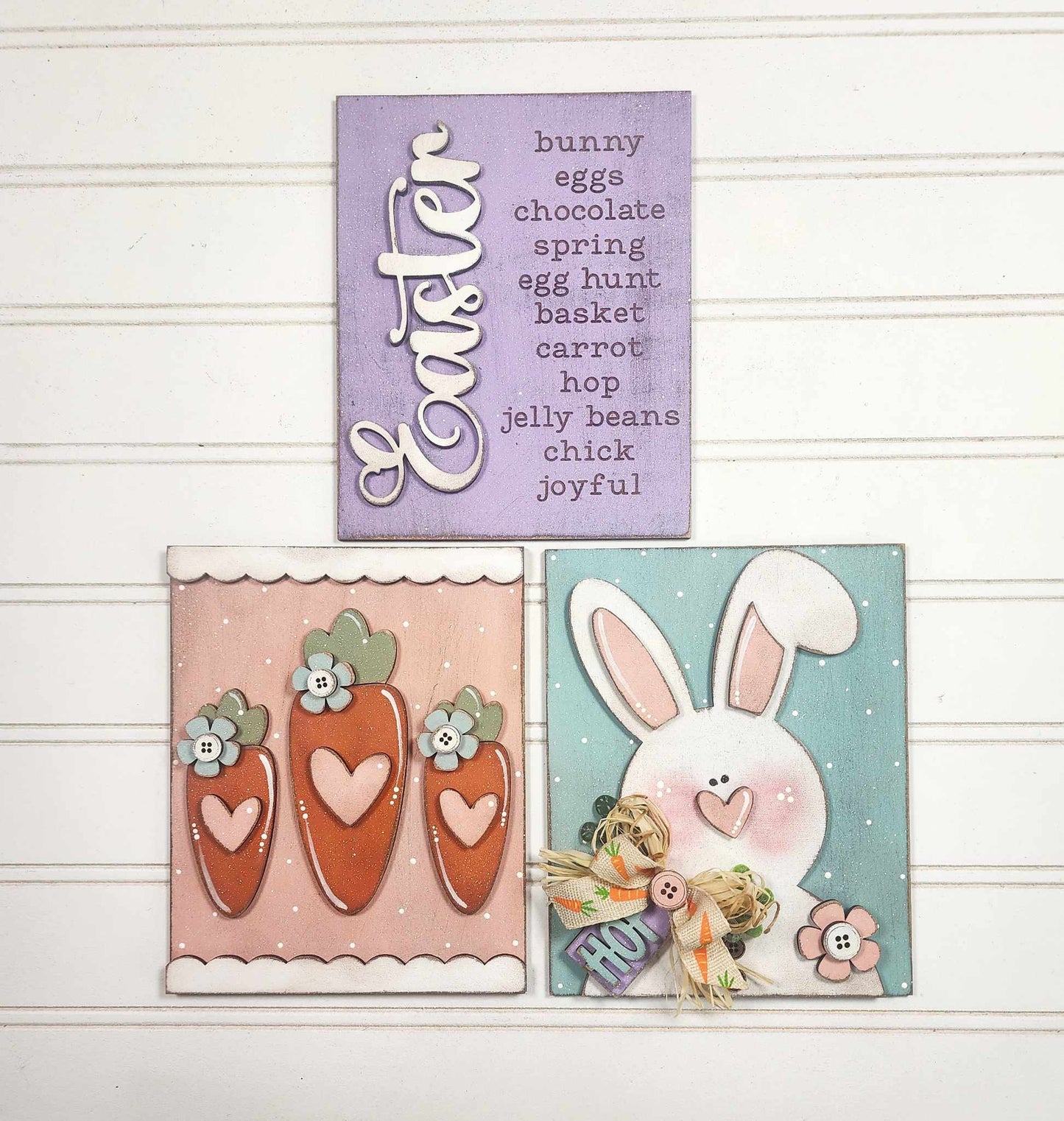 Three Easter-themed cards on white: Top has words like "bunny" and "chocolate," bottom left shows carrots with bows, and bottom right displays a pink-eared white bunny holding Janet's Craft Corner's "Easter Words Farmhouse Sign,” ideal for your DIY home decor.