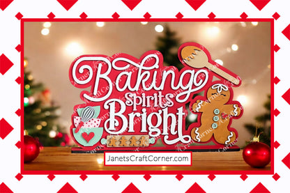 The "Baking Spirits Bright" Shelf Sitter from Janet's Craft Corner features playful lettering with holiday elements like a gingerbread man, spoon, and holly on a hand-painted background with blurred Christmas lights. A red diamond border adds charm. Visit JanetsCraftCorner.com for this DIY decor kit.