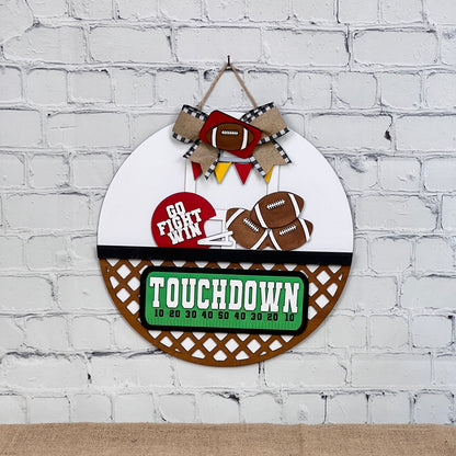 Janet's Craft Corner offers a DIY kit featuring a round wall decor with football themes. It includes "Go Fight Win" and "Touchdown" text, football and goalpost images, and fabric ribbons. Ideal for fans to get creative with this hand-painted Door Hanger Interchangeable Base kit!.