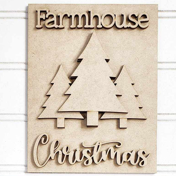 The Farmhouse Christmas Interchangeable Sign from Janet's Craft Corner displays the phrase "Farmhouse Christmas" surrounding three carved trees set against a pale wood background, making it an ideal choice for DIY home decor enthusiasts.