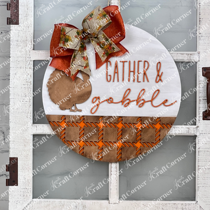 The Gather & Gobble Door Hanger from Janet's Craft Corner is a DIY home decor craft kit that features the phrase "Gather & gobble" beautifully hand-painted alongside an orange and brown turkey design. The piece is adorned with a large, festive bow in orange and green, complemented by orange checkered borders, making it a perfect addition to your home décor.