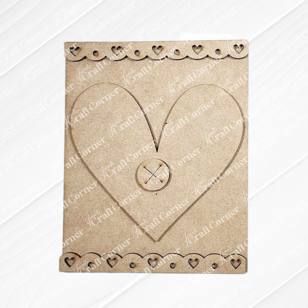 A charming accent for a DIY craft kit, Janet's Craft Corner's Heart Interchangeable Sign features a beige craft board with a large heart cut-out in the center and delightful button design. The border, adorned with small heart patterns, makes it ideal for home decor projects.