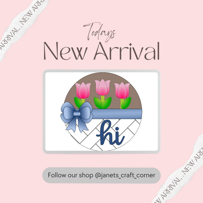 A DIY craft kit by Janet's Craft Corner, featuring three pink tulips in a brown circle above a blue ribbon with "hi" in cursive. Perfect seasonal home décor, set on a light pink background with the text: "Today's New Arrival." Follow our shop @janets_craft_corner.