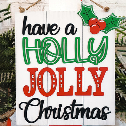 Create your own holiday sign with the "Holly Jolly Christmas Sign" DIY kit from Janet's Craft Corner. The kit features the text "Have a Holly Jolly Christmas" in decorative fonts, with "Holly" in green and "Jolly" in red adorned with stars. It includes a holly graphic at the top and an evergreen branch background, making it perfect for festive decoration.