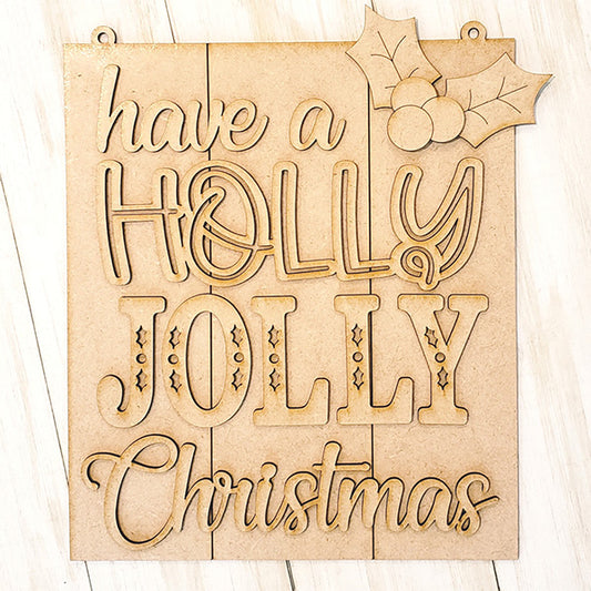 The Holly Jolly Christmas Sign from Janet's Craft Corner is a DIY kit featuring "have a HOLLY JOLLY Christmas" in various fonts, accented with holly and berries on light wood, ideal for festive home décor.