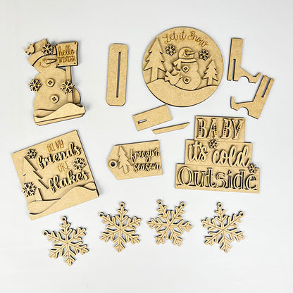 The Hello Winter Decor Set by Janet's Craft Corner includes 6 assorted decorative wooden cutouts, featuring a snowman, snowflakes, tags, and phrases like "baby it's cold outside" and "hello winter," perfect for crafting charming winter DIY decor.