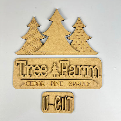 The Tree Farm Interchangeable Insert, a DIY home decor kit from Janet's Craft Corner, showcases hand-painted wooden decor with three stylized trees and text that reads "Tree Farm - Cedar - Pine - Spruce" with "U-Cut" below. The trees are lined up neatly, and the text is cut from comparable material, making it an ideal choice for holiday decorations.