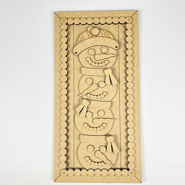 The Stacked Snowmen Shelf Leaner by Janet's Craft Corner is a wooden puzzle kit featuring a snowman with hat and scarf, set in a frame with circular patterns. Its intricately cut, unpainted pieces highlight the wood's texture, making it an ideal DIY holiday decor project.