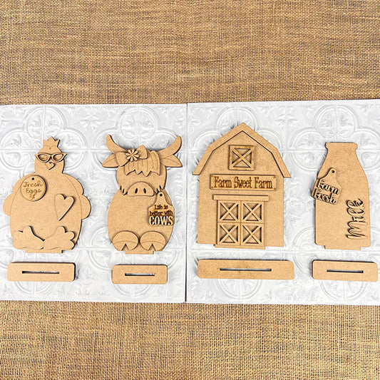 Janet's Craft Corner presents the Farm Standing Mini Shelf Sitters, a set of 4 wooden ornaments with slotted bases: a chicken "Farm Fresh Eggs," cow "I’m in a Moo-d," barn "Farm Sweet Farm," and milk bottle "Farm Fresh Milk," perfect for adding rustic farmhouse charm to any space.