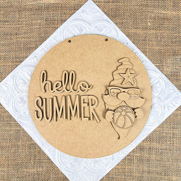 The Hello Summer Gnome Door Hanger from Janet's Craft Corner features a gnome with a beach ball and a star-patterned hat on a burlap background with an embossed mat. Ideal for DIY home décor, this round wooden sign displays "Hello Summer" and is perfect as part of your craft kit!.