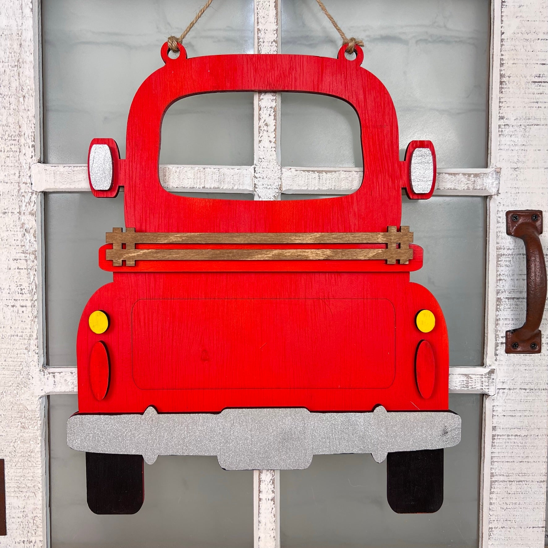 The Antique Truck Interchangeable Base - Painted by Janet's Craft Corner is a wooden red truck decor with yellow tail lights and a silver bumper, ideal for hanging on doors with white window panes as versatile, charming décor.