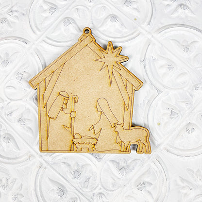 The "Color Your Own Ornament | DIY Decoration Kits" by Janet's Craft Corner lets you create a wooden nativity scene featuring Mary, Joseph, and baby Jesus in a manger, accompanied by a sheep and star overhead. Perfect for home décor, this kit allows you to personalize your piece against a white textured background.