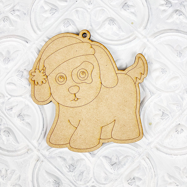 Introducing Janet's Craft Corner's Color Your Own Ornament | DIY Decoration Kits: a wooden puppy wearing a Santa hat on a patterned white background. This ornament kit offers an easy-to-follow design with festive charm, allowing you to personalize your Christmas decorations. Perfect for creative home décor projects.