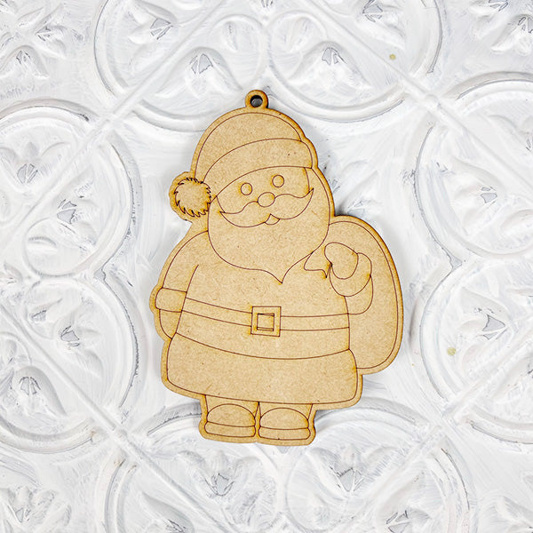 Introducing the Color Your Own Ornament from Janet's Craft Corner, a stylish wooden Santa Claus ornament that is perfect for any DIY Decoration Kit. Featuring a classic hat, belt, and sack, it boasts a smooth finish and complements a textured white background beautifully, adding charm to your home décor craft collection.