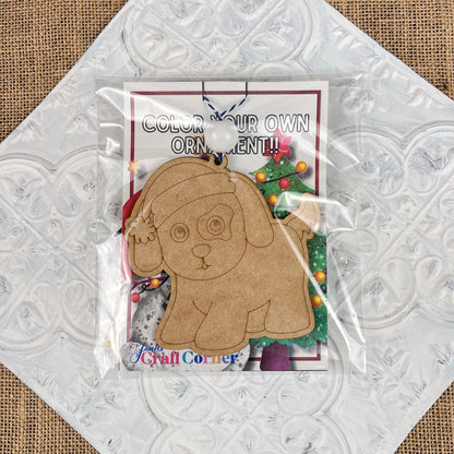 Janet's Craft Corner presents the Color Your Own Ornament DIY Decoration Kits, featuring a wooden cutout puppy adorned with a Santa hat, perfect for adding festive joy to your home décor. Displayed on a decorative background, it offers an ideal canvas for personalizing your holiday cheer.