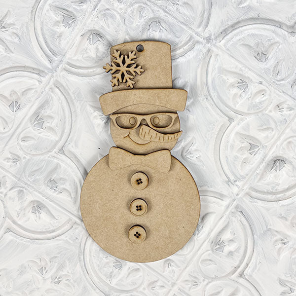 The Vintage Snow Couple Ornaments from Janet's Craft Corner is a DIY decoration kit featuring hand-painted wooden snowman ornaments adorned with a top hat, bow tie, and buttons, complete with a snowflake detail on the hat. This kit beautifully captures the charm of a vintage snow couple against a textured white background.