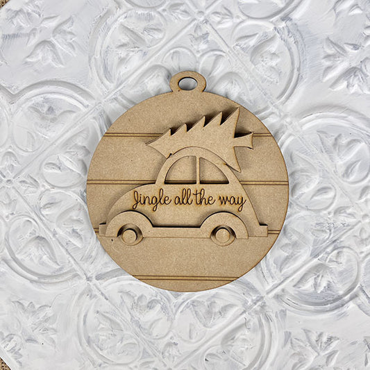 The Jingle All the Way Volkswagen Ornament DIY craft kit by Janet's Craft Corner features a charming wooden car with a Christmas tree on top against a textured white background, adding festive cheer with "Jingle all the way" to any space.