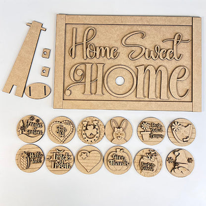 The "Home Sweet Home Interchangeable Set Shelf Sitter" by Janet's Craft Corner is a DIY home decor kit with 1 sign and 12 seasonal inserts including pumpkin, turkey, clover, snowman, and heart designs.