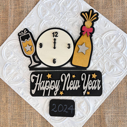 Introducing the "New Year Interchangeable Insert - Painted" from Janet's Craft Corner. This decorative piece features a striking image of a clock at midnight, accompanied by a champagne bottle and glass, making it a perfect addition to your home decor. "Happy New Year" is elegantly inscribed alongside star accents, with "2024" standing out below. The textured light-colored background ensures its suitability as an interchangeable insert for any festive setting.