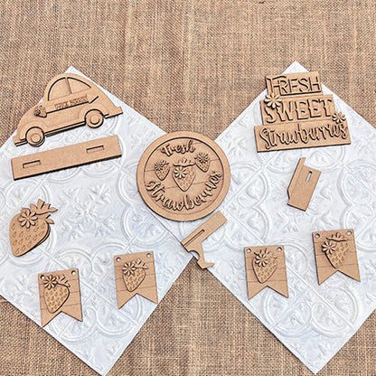 Janet's Craft Corner offers the Strawberry Decor Set, a DIY seasonal home decor craft kit featuring laser-cut wooden crafts. The six-piece set includes a car, circle ornaments, banners, and charming signs like one reading "Fresh Sweet Strawberries," ideal for DIY enthusiasts.