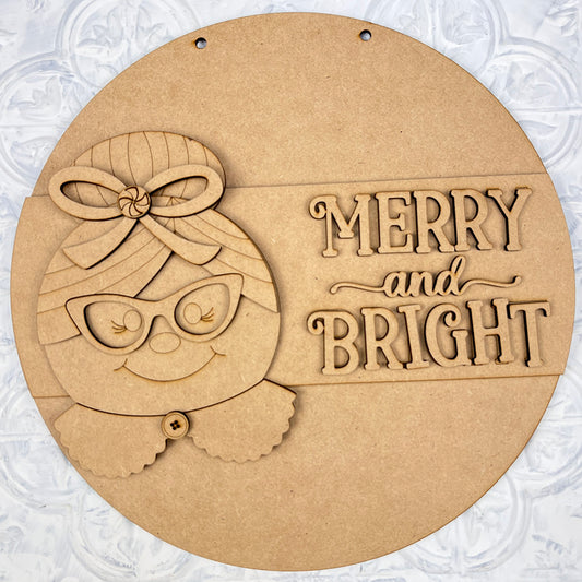 The Mrs. Claus Merry & Bright Round Sign DIY Home Decor Kit by Janet's Craft Corner offers everything you need to craft a wooden holiday wall decoration. It showcases a festive character adorned with glasses, a bow, and a scarf, alongside the bold lettering "Merry and Bright" on the right side. This kit is ideal for adding customized decor to your home this season.