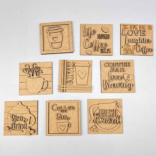 Set of ten "Coffee Squares" by Janet's Craft Corner—square and rectangular wooden plaques with coffee-themed designs like "Life Happens Coffee Helps." Ideal for DIY home decor or adding charm to small spaces. Displayed on a white background.