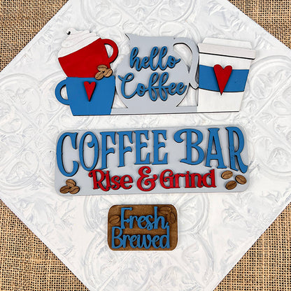 Textured background featuring wooden coffee-themed signs including "Hello Coffee" with blue cups and "Coffee Bar Rise & Grind" in blue and red, offers interchangeable craft inserts for a touch of variety. The "Fresh Brewed" sign is presented on a brown plaque adorned with coffee bean illustrations, resembling a hand-painted DIY craft kit from Janet's Craft Corner's Coffee Bar Interchangeable Insert collection.