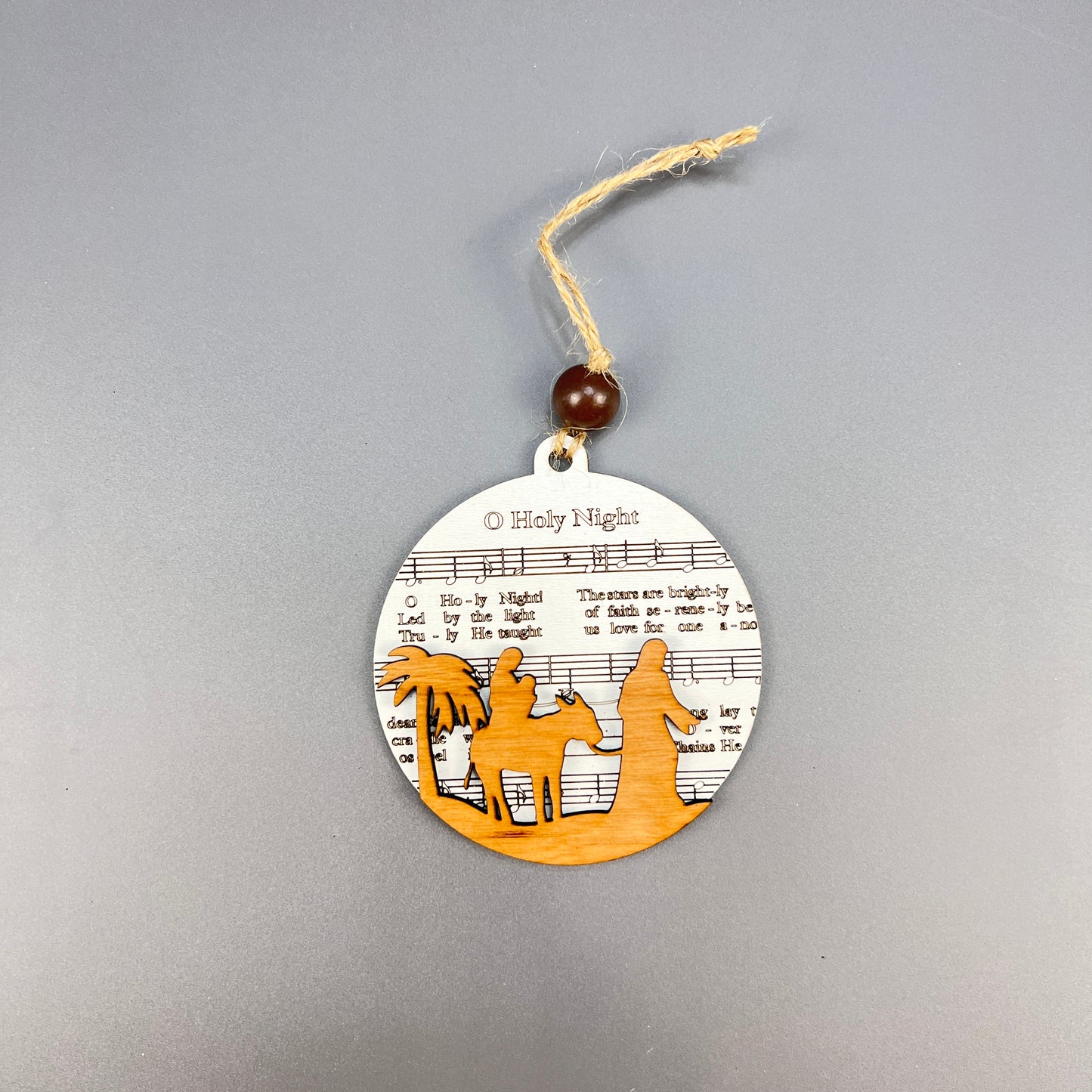 Introducing Janet's Craft Corner's Sheet Music Ornaments: a round wooden creation that exudes rustic charm with its delicate design, perfect for music lovers seeking distinctive decorations.