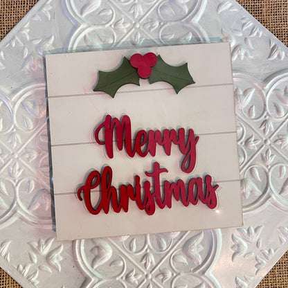 A festive 6 inch square from Janet's Craft Corner features red "Merry Christmas" text with green holly and red berries on a white embossed tile background.