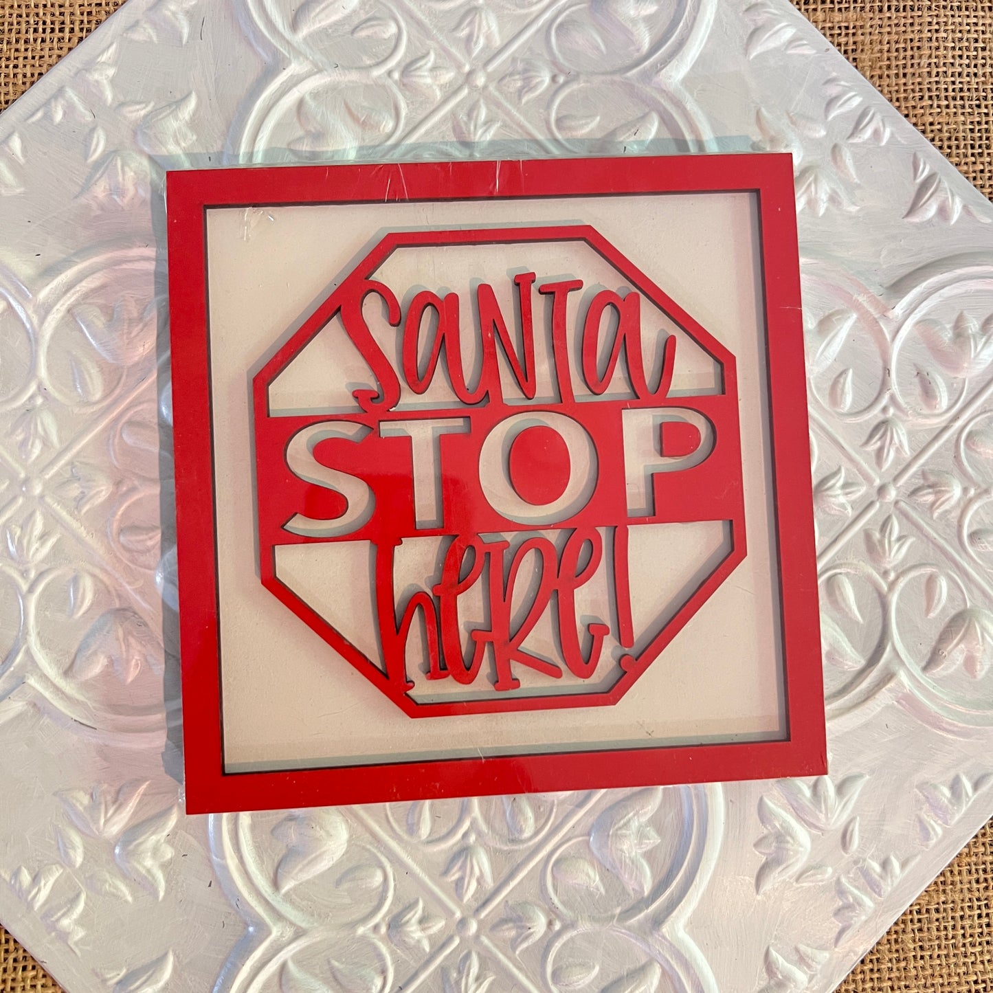 A red and white stop sign-shaped decor from Janet's Craft Corner features playful "Santa STOP here!" lettering, displayed on their 6 inch squares with a white textured background.