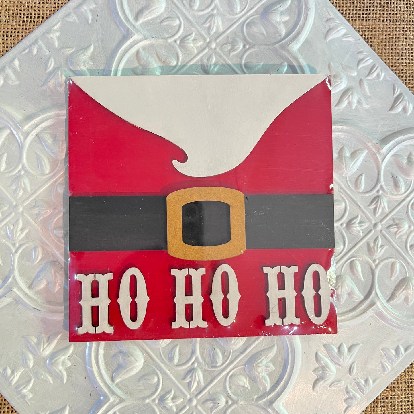 Janet's Craft Corner 6 inch square sign features Santa’s red suit with a black belt, gold buckle, and bold “HO HO HO” text on a textured silver background.