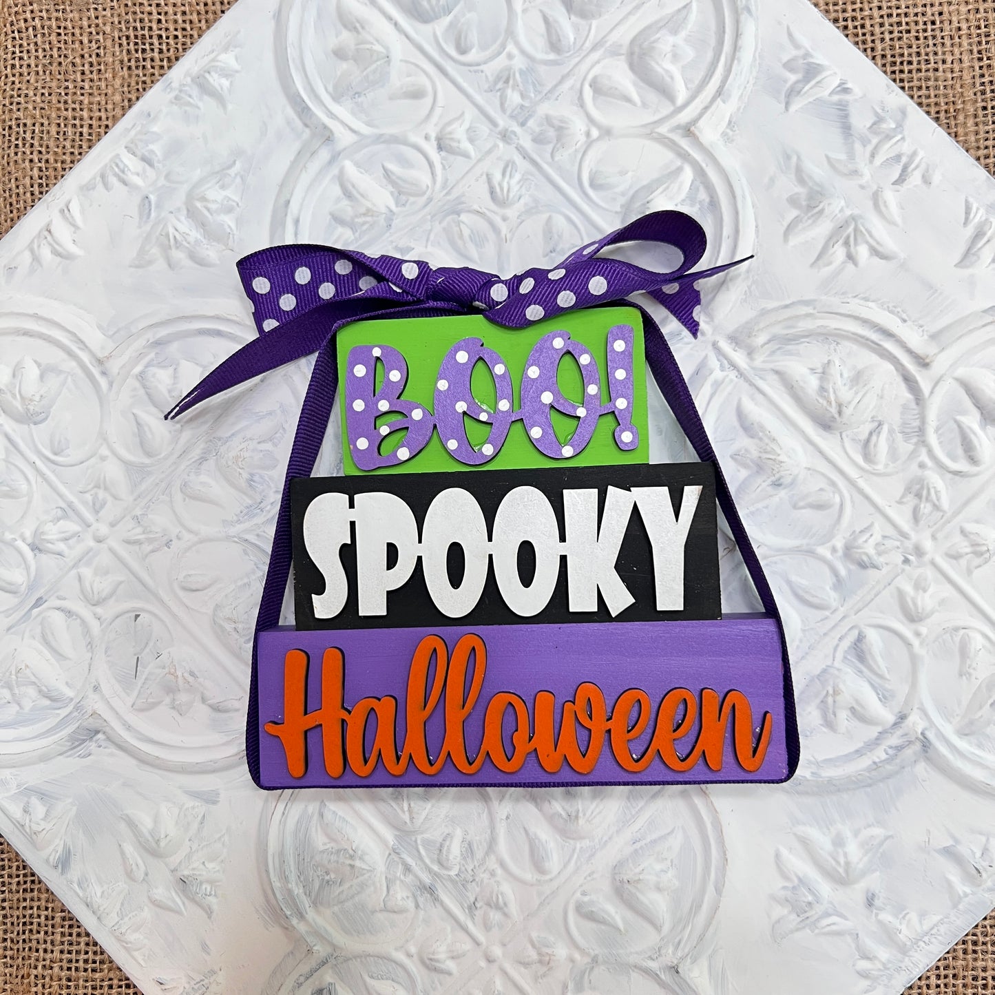 Janet's Craft Corner Word Stacks - Painted features a decorative Halloween sign with "BOO!" in green, "SPOOKY" in black and white, and "Halloween" in orange on a purple base, topped with a purple polka dot ribbon.