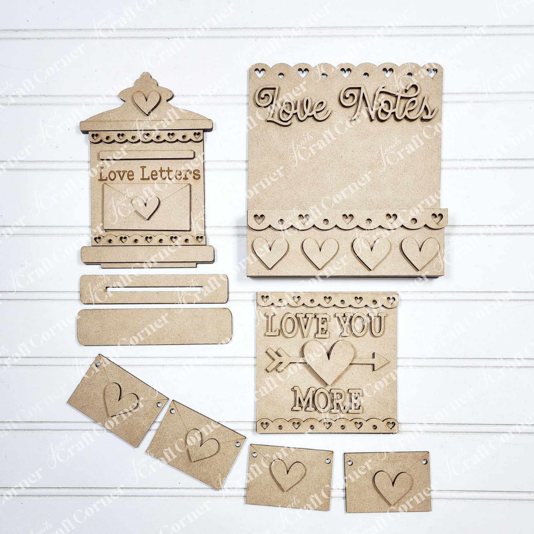 Explore Janet's Craft Corner's Valentine Love Letters Decor Set, ideal for home décor. This DIY craft kit includes delightful elements like a mailbox shape, small hearts, and hanging banners with designs such as "Love Notes" and "Love You More" to personalize your space.